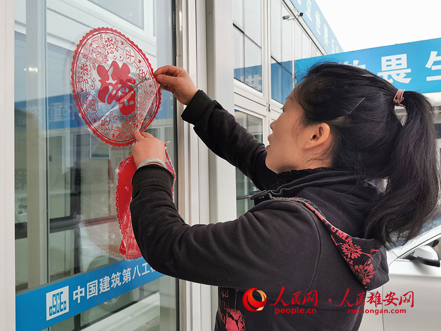 曾世銀的妻子牟倫萍與工作人員一起貼福字。李兆民攝