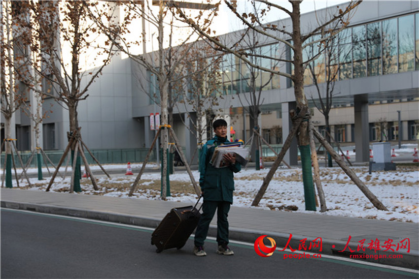 孫小偉在雄安市民服務中心裡拖著行李箱投遞報紙和EMS件。胡宇濃/攝