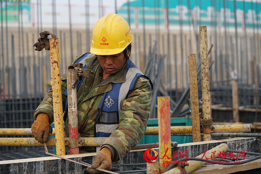 武憲民正在用尺子丈量兩個模板之間的的距離。“模板支設的工作是為混凝土澆筑打基礎，做不好會影響下一個工序的正常進程。”李兆民攝