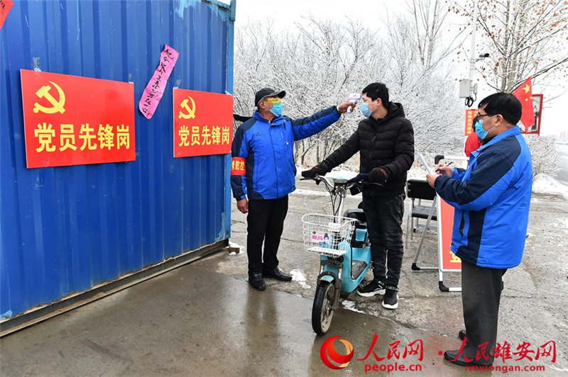 容城縣白塔村66歲老黨員康佔芬、李金龍在雪中值班。劉向陽攝