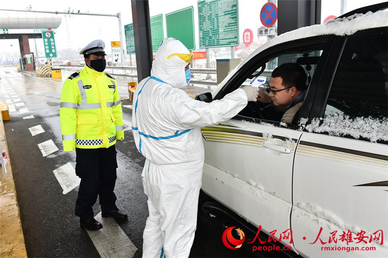 雄安全面加強人流密集場所管控，加大對火車站、汽車站、碼頭、商場等重點場所的防控力度，堅決防止交叉感染和疫情擴散。圖為容城縣公安局民警在雪中檢查，對出行車輛進行司機進行體溫監測。劉向陽攝