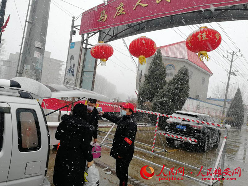 漫天飛舞的大雪和戴紅帽忙碌的身影交相輝映，映出了一道美麗的風景線。雄縣宣傳部圖