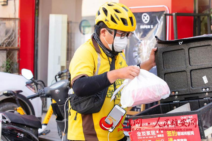 烈日下，外賣小哥取到外賣准備配送。李康樂攝