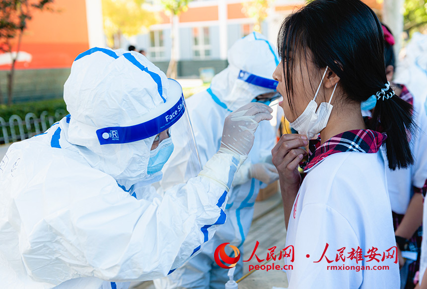 8月25日，在雄安新區雄縣第二小學，醫護人員正在為學生進行核酸檢測。劉丹攝