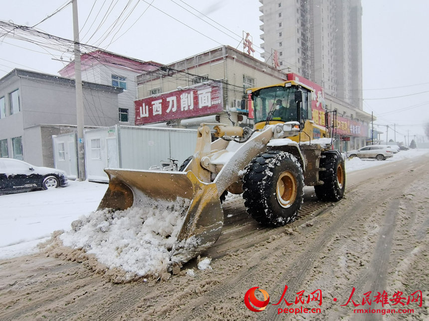 雄县米家务镇组织人员机械清理积雪。丁敏摄