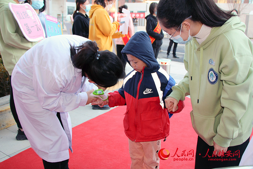 圖為雄安容和樂安幼兒園開學第一天，校醫為學生測體溫。雄安容和樂安幼兒園供圖