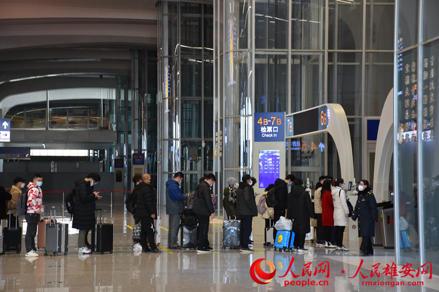 正在排隊等候檢票登車的旅客。關啟迪 攝