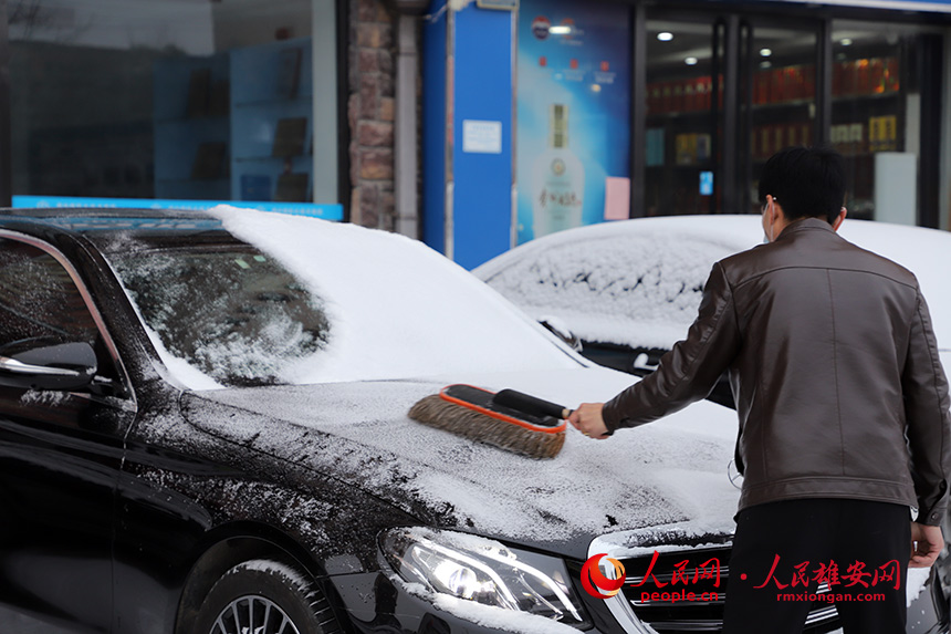 一大早，雄安市民正在清理車上覆蓋的積雪。李康樂攝