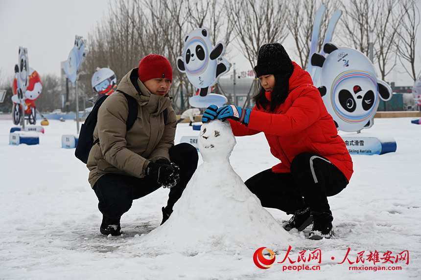 大雪天，群眾紛紛來到雄安新區冬奧文化廣場游玩。圖為正在堆雪人。胡忠攝