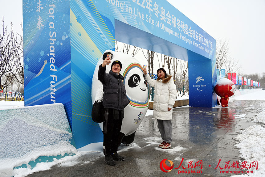 大雪天，群眾紛紛來到雄安新區冬奧文化廣場游玩。圖為市民與“冰墩墩”合影。胡忠攝