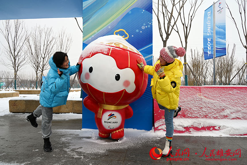 雪天，群眾紛紛來到雄安新區冬奧文化廣場游玩。圖為與“雪容融”合影。胡忠攝