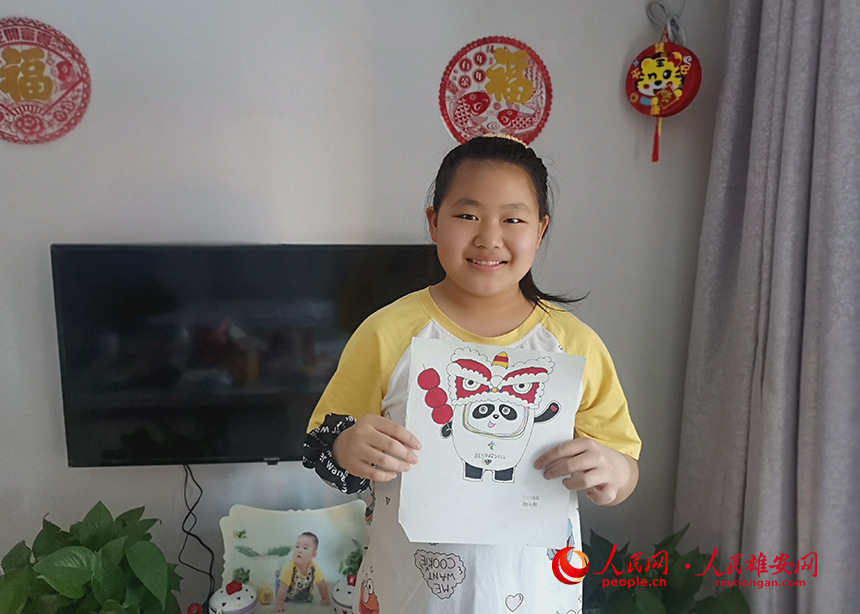 六年級一班學生楊子杉手持冬奧主題繪畫。楊長青攝