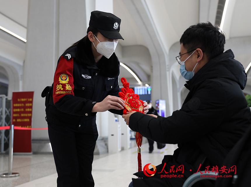 雄安站派出所的民警向旅客贈送中國結。人民網 宋燁文攝