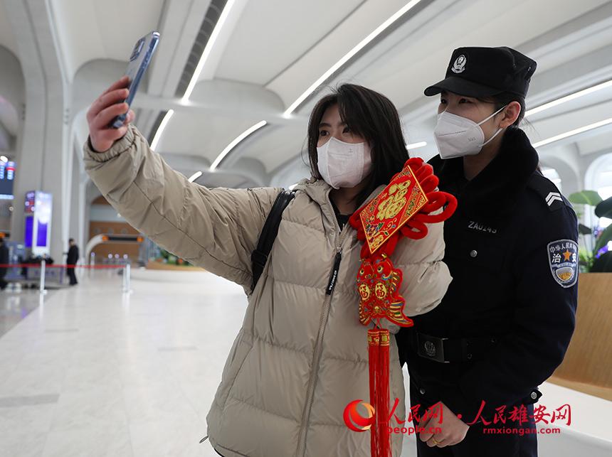 收到中國結的旅客手持中國結與民警合影。人民網 宋燁文攝
