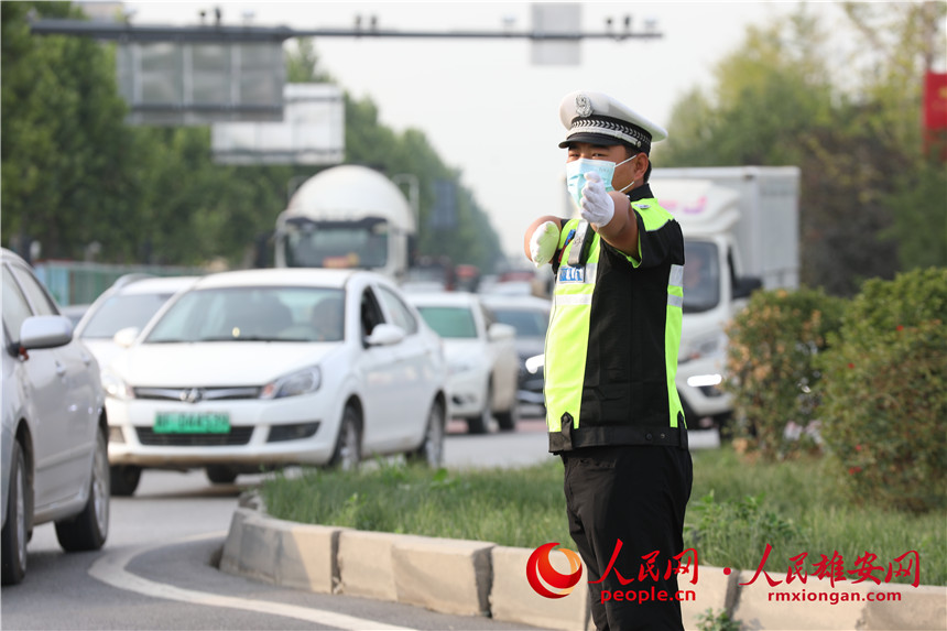 交警冒著高溫天氣，引導車輛通行暢通。人民網 李兆民攝