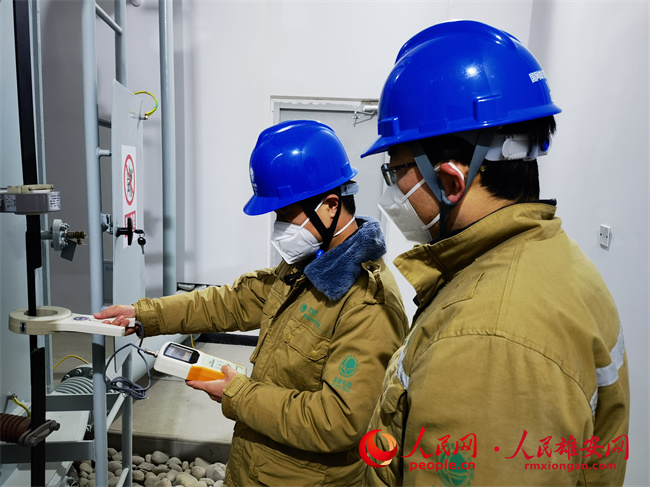 12月15日，國網雄安新區供電公司王濤、樊懷遠正在測量變壓器鐵芯接地電流，確保設備安全投運。張啟光攝