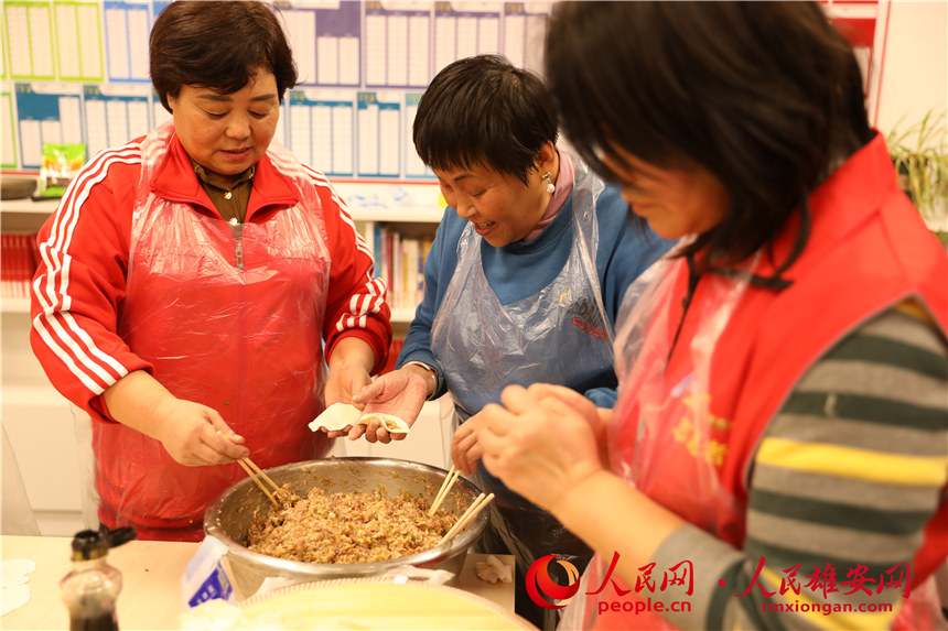 图为容西片区飞泉社区组织回迁居民包饺子。人民网 杨华龙摄