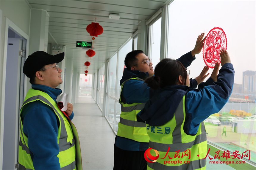 建设者们正在贴窗花。中建三局集团北京有限公司供图
