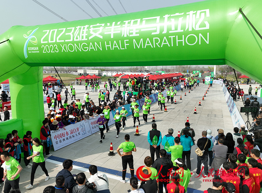2023雄安半程马拉松现场，参加健康跑的选手们即将越过终点。人民网 李兆民摄