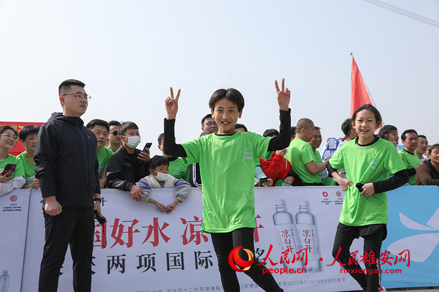 2023雄安半程马拉松现场，完成健康跑的小选手正在庆祝胜利。人民网 李兆民摄