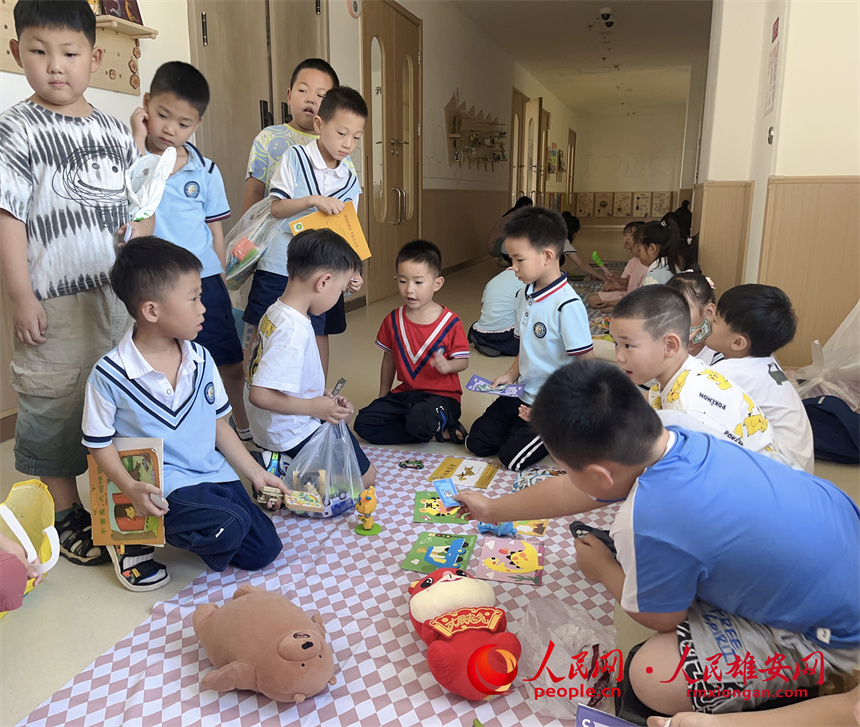 圖為“集市行樂”活動中，學生用“悅容幣”進行交易。雄安容和悅容幼兒園供圖