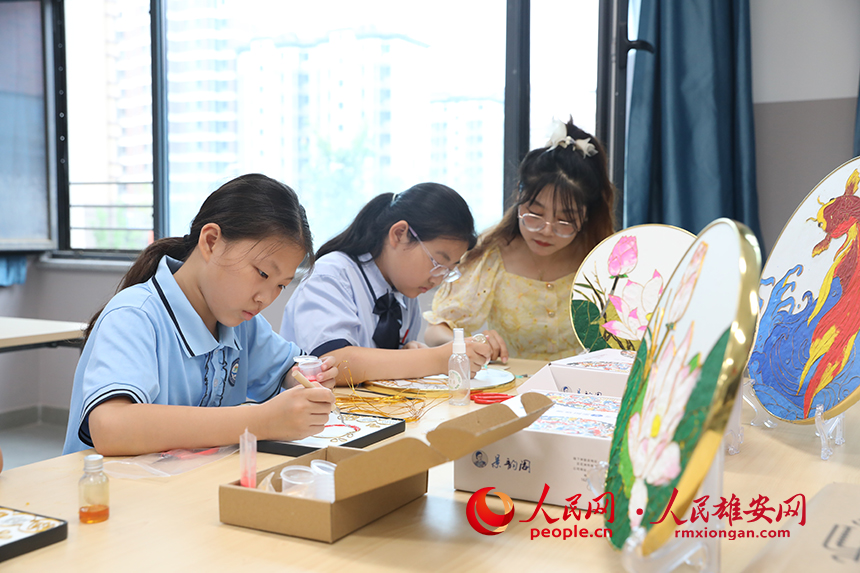 暑假期間，雄安容和樂民小學老師指導學生制作中國傳統工藝品——掐絲琺琅畫，體驗非遺藝術的制作流程。人民網 李兆民攝