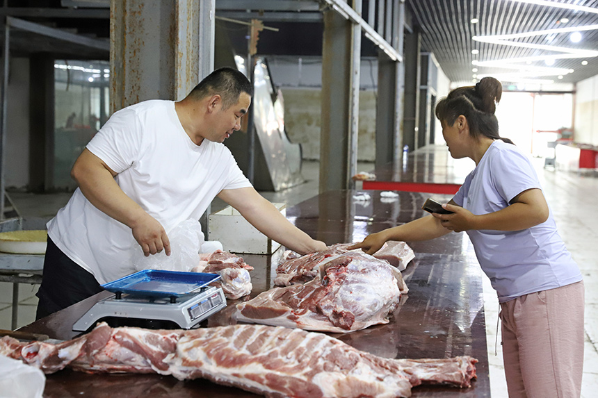 8月25日，涿州市新發地大石橋批發市場生鮮賣場，顧客在攤位前挑選豬肉。熊華明攝