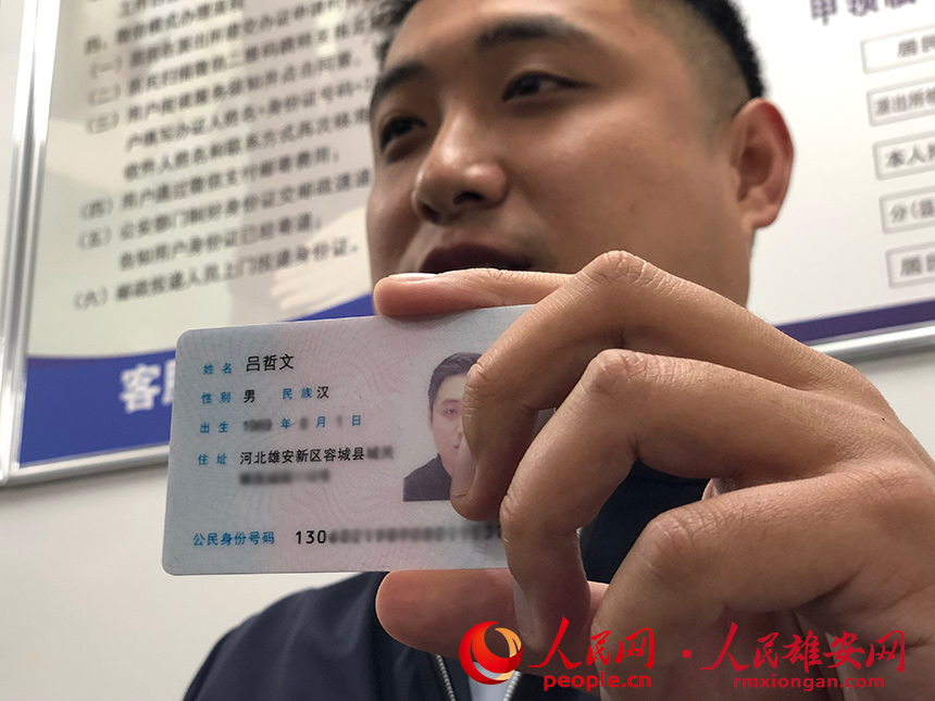 吕哲文展示自己的新身份证。人民网记者 宋烨文摄