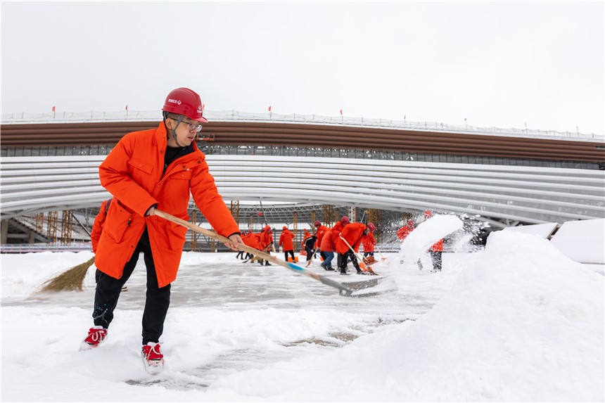 雄安体育中心项目组织建设者开展清雪除冰工作。北京城建供图