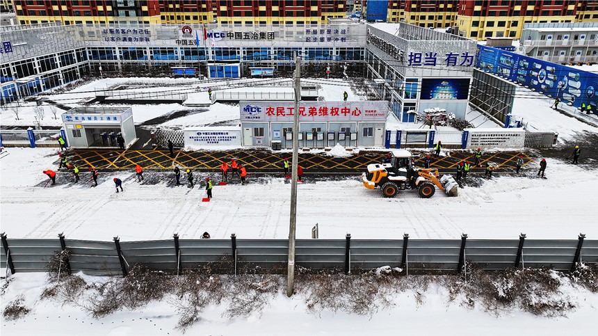 雄東安置房B單元項目組織建設者開展清雪除冰工作。中國五冶供圖