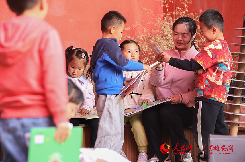 4月23日，雄安北海幼儿园师幼合作在幼儿园白洋淀微景观进行布置，开展荷塘趣味读书活动。人民网记者 李兆民摄