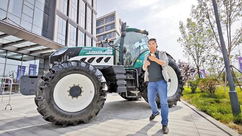 5月27日,2024雄安未来之城场景汇“雄安无人农场技术应用大赛”决赛开赛。图为山东易田网络科技有限公司华北大区经理杨进文正在演示如何对智能驾驶拖拉机进行远程控制操作。 河北日报记者 曹铮摄