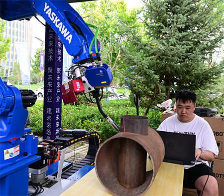 6月12日，2024雄安未來之城場景匯雄安國際服務機器人大賽決賽開賽。這是河北工業大學機械工程學院建筑機器人及智能裝備團隊成員正在調試焊接機器人。 河北日報記者耿輝攝