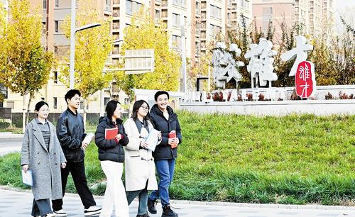 11月11日，雄安新区容东片区街头，一群年轻人前往雄才大厦咨询人才政策。 本报记者 刘光昱摄