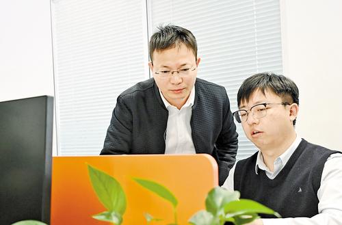 12月3日，雄安興元科技有限公司創始人鞏文通（左）和同事進行技術交流。 本報記者 劉光昱攝