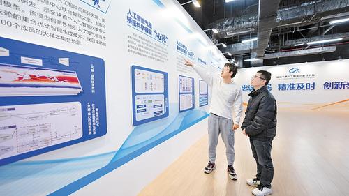近日，在雄安氣象人工智能創新研究院展示大廳，竇則勝（左）和工作人員正在探討人工智能氣象預報科學模型“風源”的迭代升級工作。本報記者 李 暢攝