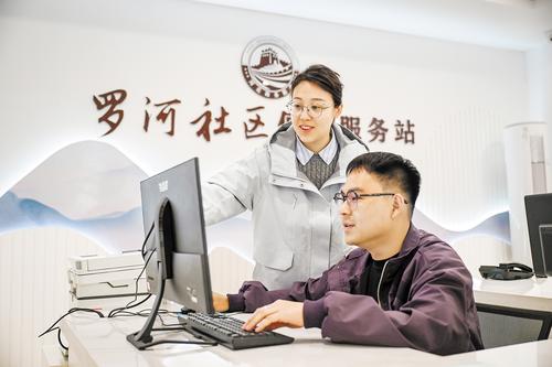 4月17日，李澤（左）與工作人員一起討論社區治理方案。 本報記者 李東宇攝