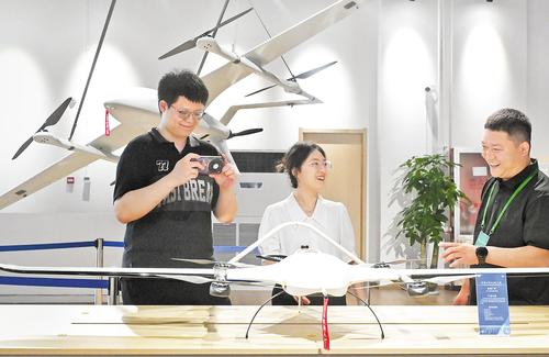 6月10日，雄安未来之城场景汇科创园，河北航空投资集团有限公司无人机7S旗舰店工作人员（右一）向参观者介绍无人机应用场景。本报记者 刘光昱摄