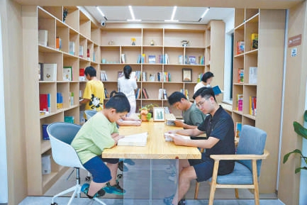 在雄安新區保障房社區,居民與子女在“四點半課堂”共同讀書。