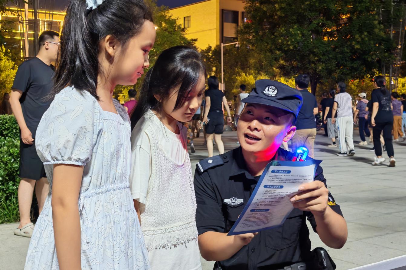 容城县公安局特巡警大队民警在新容文化广场为暑期儿童讲解安全防范知识。雄安新区公安局供图
