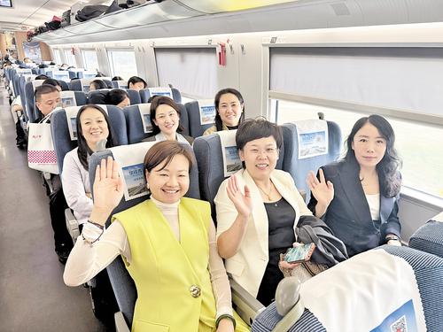 9月28日8時多，在首班復興號G8854次列車上，旅客正在揮手示意。本報記者 呂若汐攝