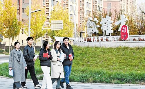 近日,雄安新区容东片区街头,前往雄才大厦咨询人才政策的年轻人在进行政策信息交流。本报记者 刘光昱摄